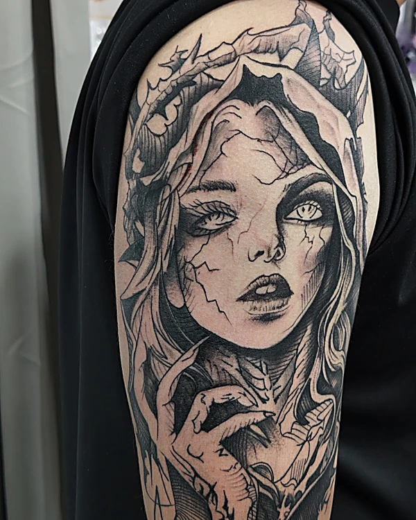 Rostro de mujer con corona de ramas en realismo negro y gris, tatuado en el brazo