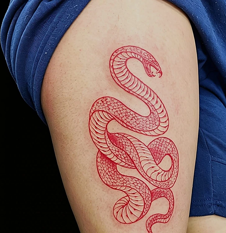 Serpiente en línea roja enroscada, tatuada en la parte alta del brazo